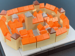 LEGO MOC orange and beige circular wall with gray platforms, bricks arranged around an inner courtyard.