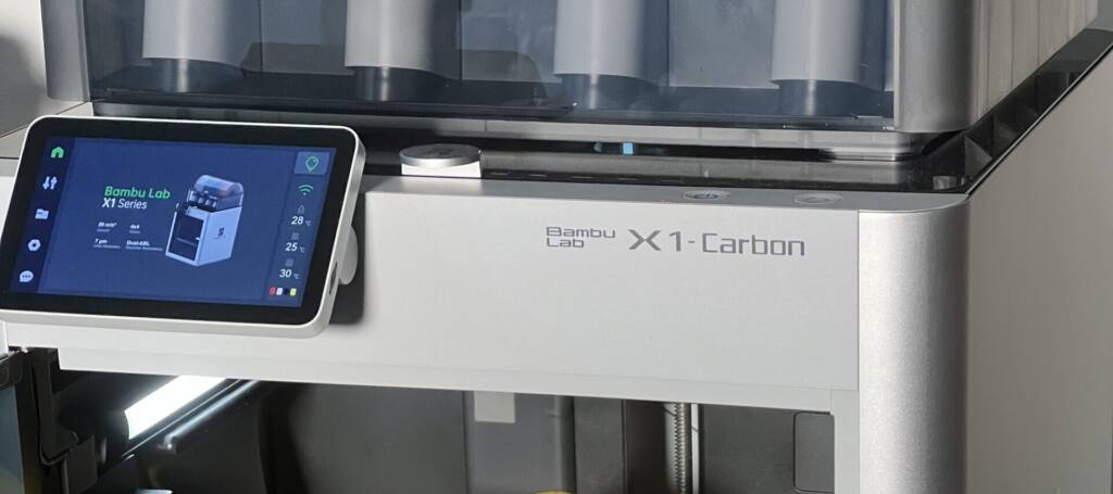 Bambu Lab X1-Carbon 3D printer with touchscreen display showing print setup controls
