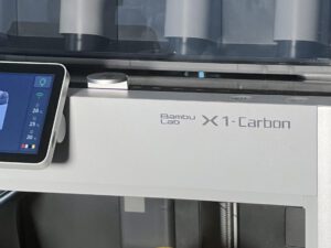 Bambu Lab X1-Carbon 3D printer with touchscreen display showing print setup controls