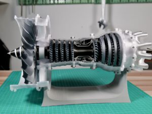 Disassembled turbine engine compressor rotor and blades on a workbench with green cutting mat.